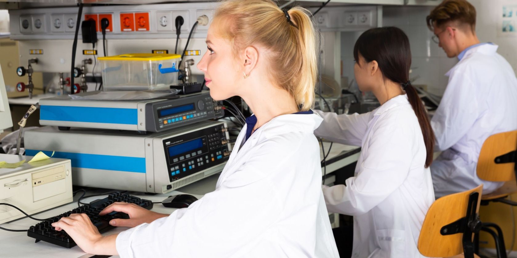 2 Frauen und 1 Mann arbeiten an PCs.