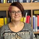 Frau vor einer Wand mit Aktenordnern