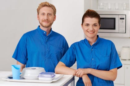 Zwei Pflegeassistenten in Berufskleidung