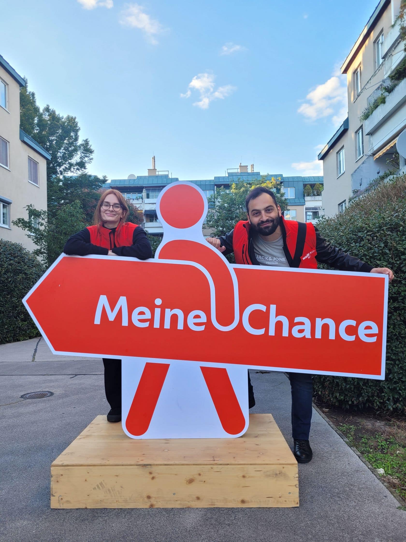 Zwei Promotor*innen im Gemeindebau mit dem "Meine Chance" Schild