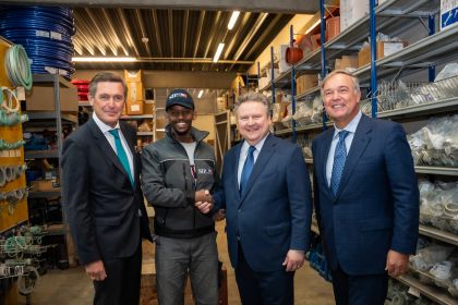 Bürgermeister Michael Ludwig, Wirtschaftsstadtrat Peter Hanke, Präsident der Wirtschaftskammer Wien Walter Ruck und ein Lehrling stehen in einem Lager