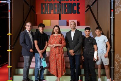 Christian Meidlinger, Barbara Novak, Marko Miloradovic und drei junge Burschen stehen vor bunten Stufen in der Future Fit Experience