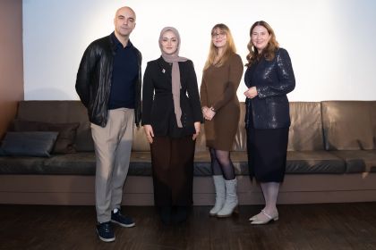 Marko Miloradovic, Menat Abdou, Victoria Himmer und Barbara Novak stehen auf einer Bühne und sehen in die Kamera