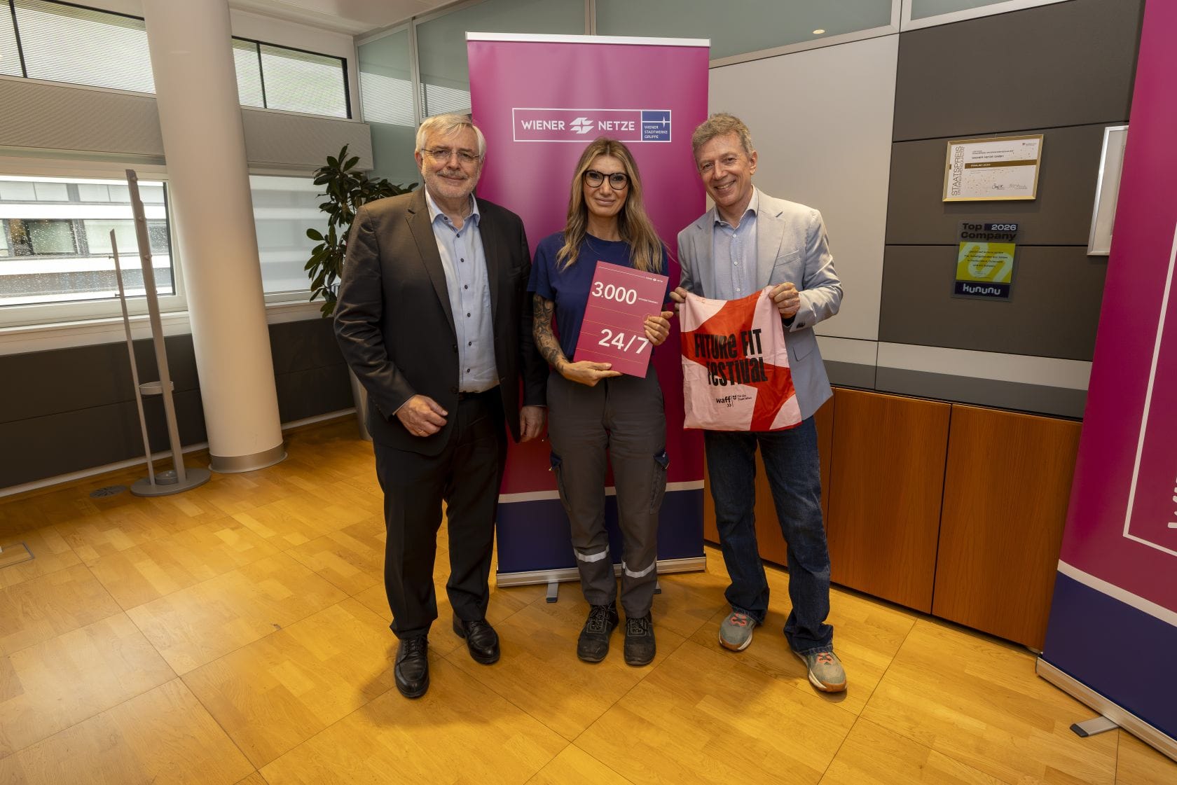 Gerhard Fida, Mary Dikan und Alex Juen stehen vor einem Rollup der Wiener Netze